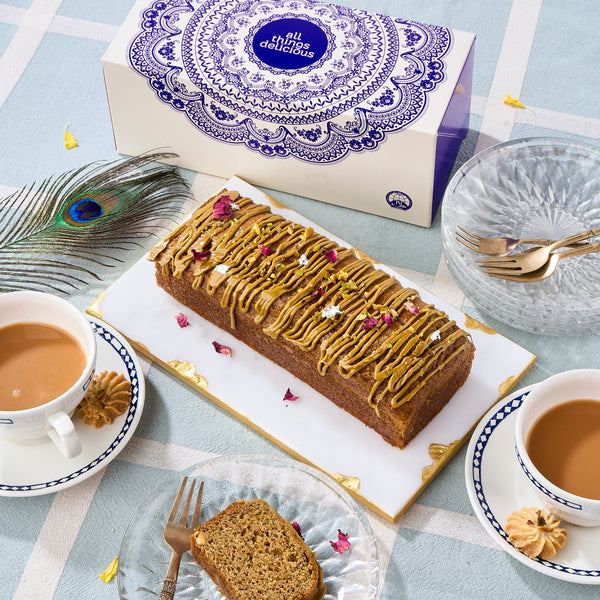 Halal Pistachio Cardamom Voyage Cake with pistachio praline drizzle and rose petals, served with masala chai