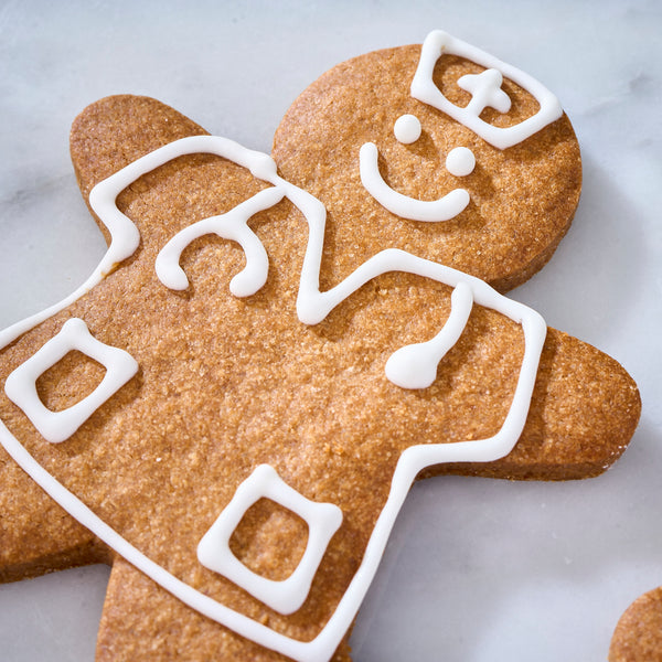 Close-up of a nurse-shaped cinnamon cookie iced with a cap, smile, stethoscope and uniform pockets