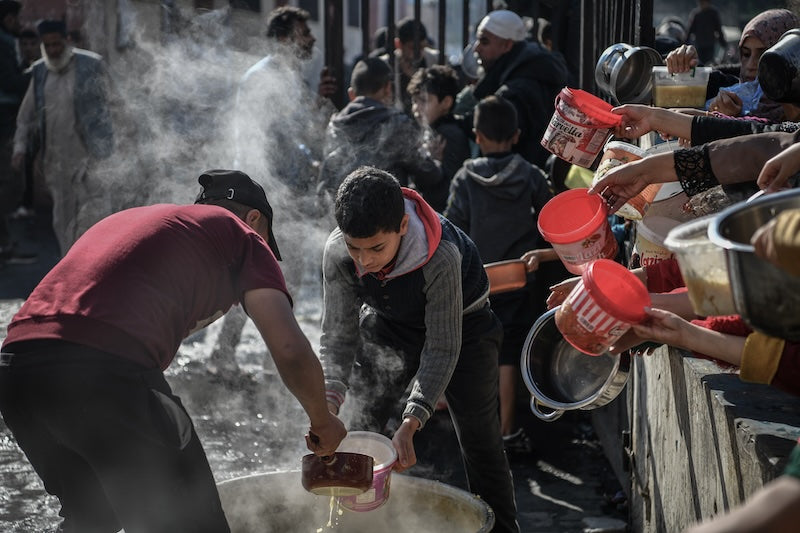 People, including children, wait in a long line to receive a small amount of food in the city of Rafah, southern Gaza Strip. Source: Unicef - Abed Zagout