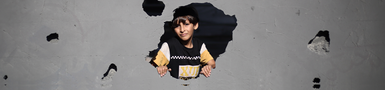 Ayman, 10- year-old, looks through a hole in the wall of his house caused by an airstrike in Rafah, southern the Gaza Strip. Source: Unicef - Eyad El Baba 06.11.2023