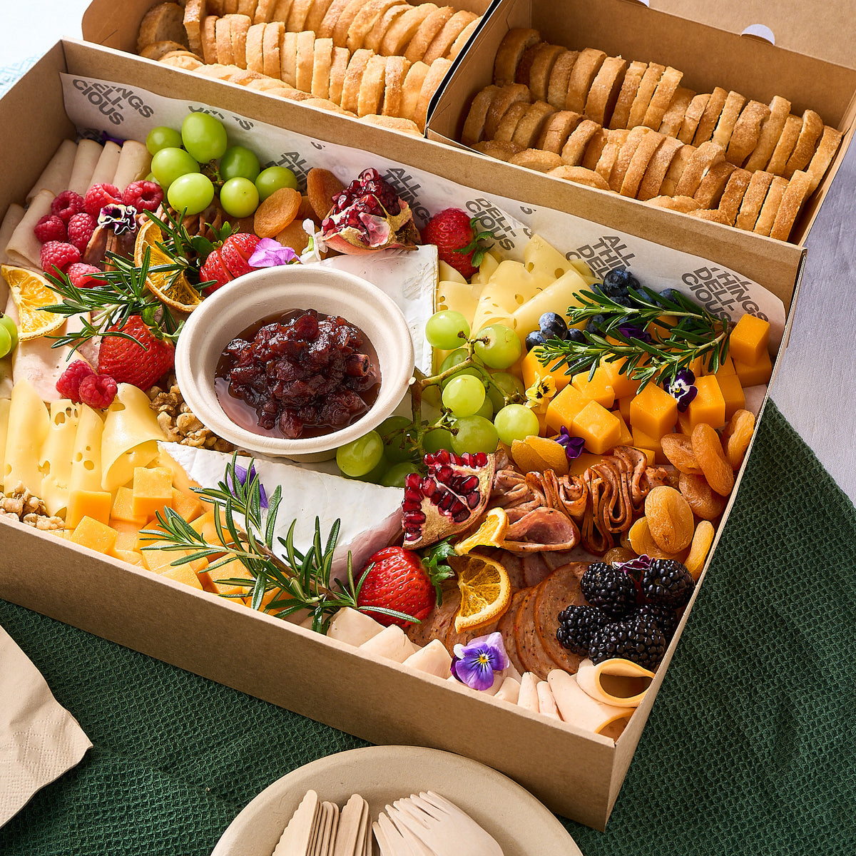 Grazing box with cheeses, cold cuts, fresh fruit, chutney and crostini