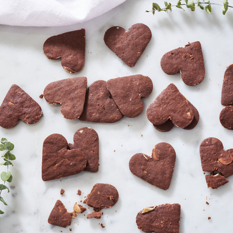 Heart-shaped chocolate cookies presented on a marble surface, one of the many options in the Abundance Gift Box