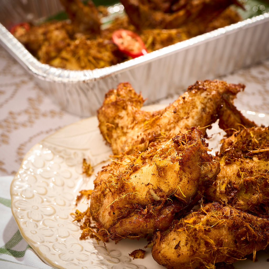 Halal ayam goreng berempah served on a white plate, crisp with fried spiced lemongrass, tray behind