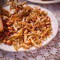 Halal crispy ikan bilis and roasted peanuts piled on a white plate, the classic nasi lemak side
