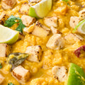 Close-up of mildly spiced pumpkin and lentil dal with golden seared cubes, curry leaves and lime
