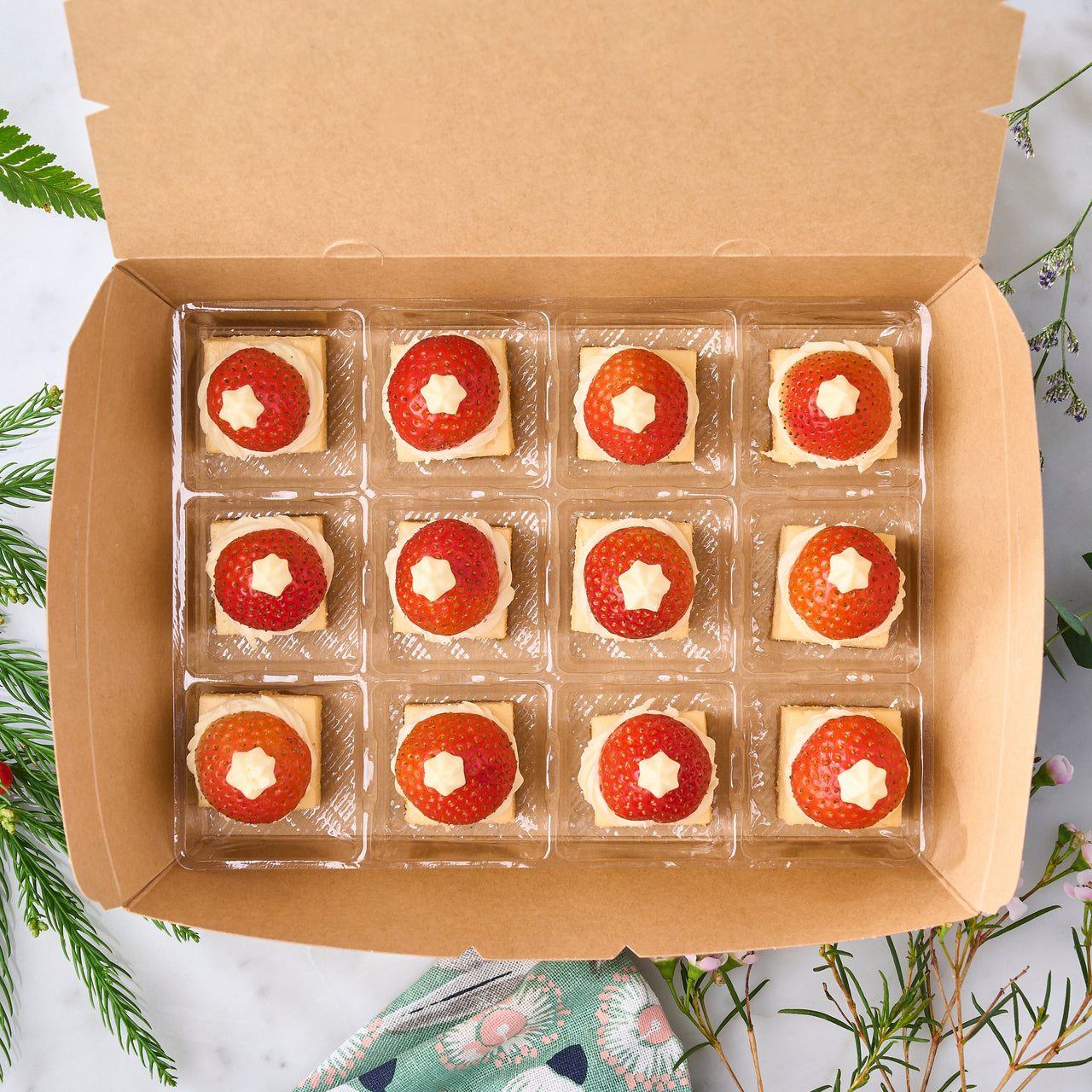 Mini cheesecakes with Santa's hat decoration presented in a festive box