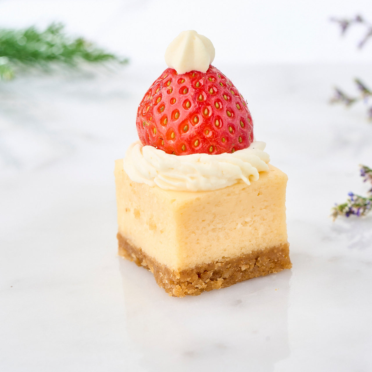 Individual mini Santa's hat cheesecake with a strawberry topping on a plate