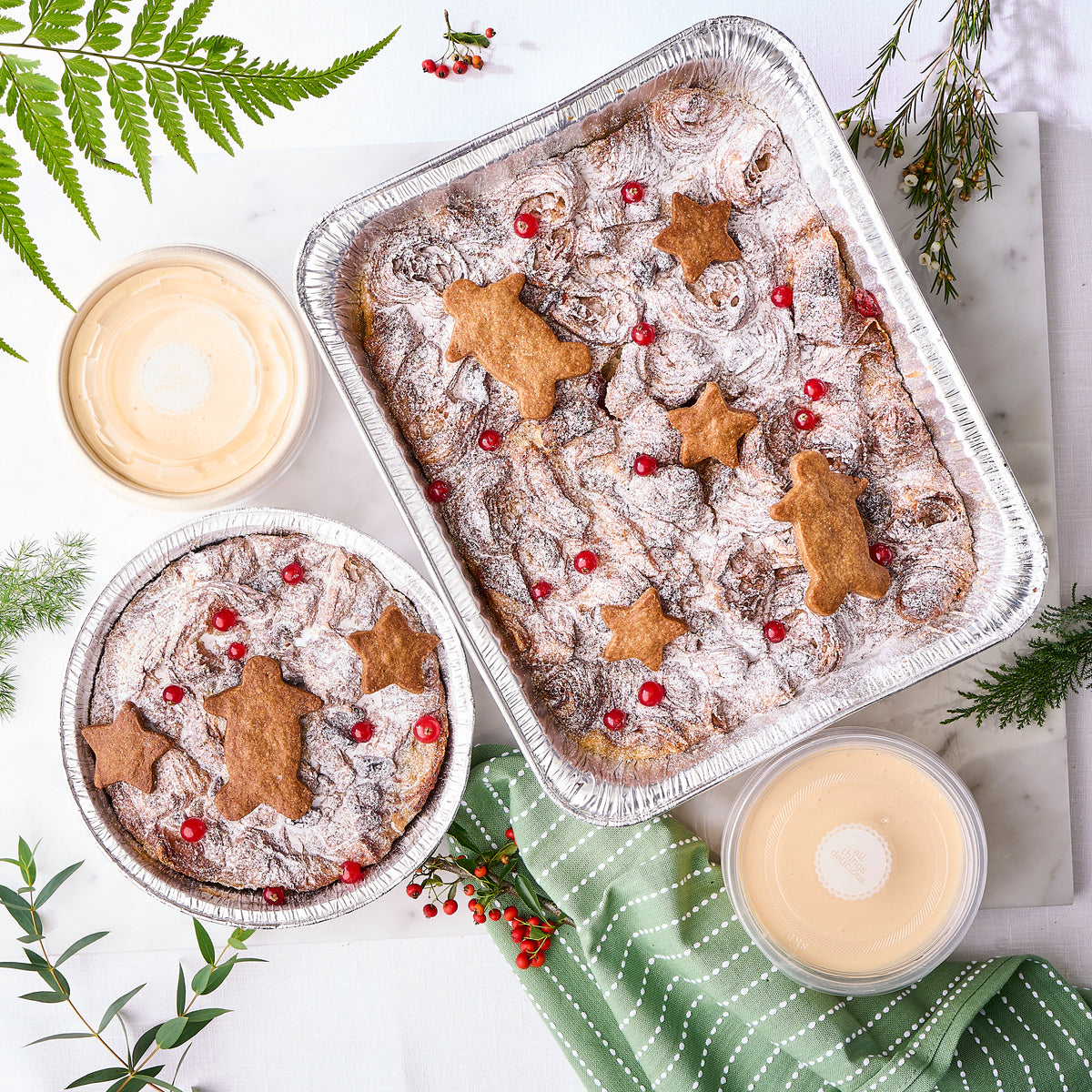 Christmas bread and butter pudding in two tray sizes with gingerbread stars and cranberries