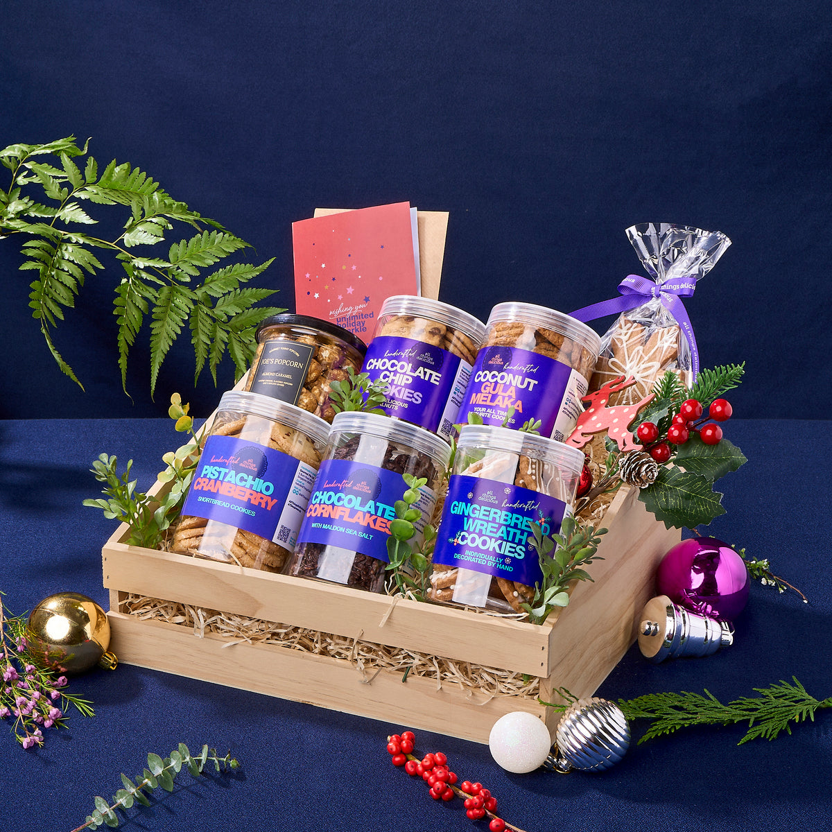 A Christmas hamper full of assorted cookie jars and pop corn, including  gingerbread wreaths and snowflakes.