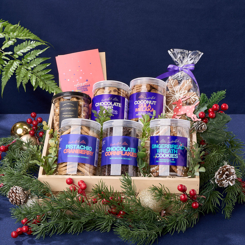 A Christmas hamper full of assorted cookie jars and pop corn, including  gingerbread wreaths and snowflakes.