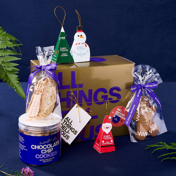 Golden Christmas gift box with jar or cookie, biscotti, teas and a ginger bread man. 