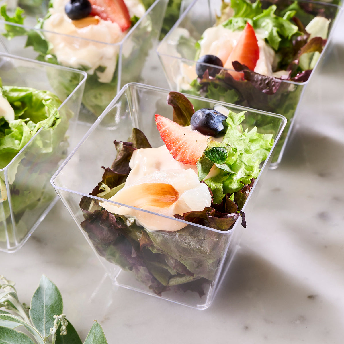 Close-up of salad cups with lychee-marinated turkey, strawberry slices and blueberries