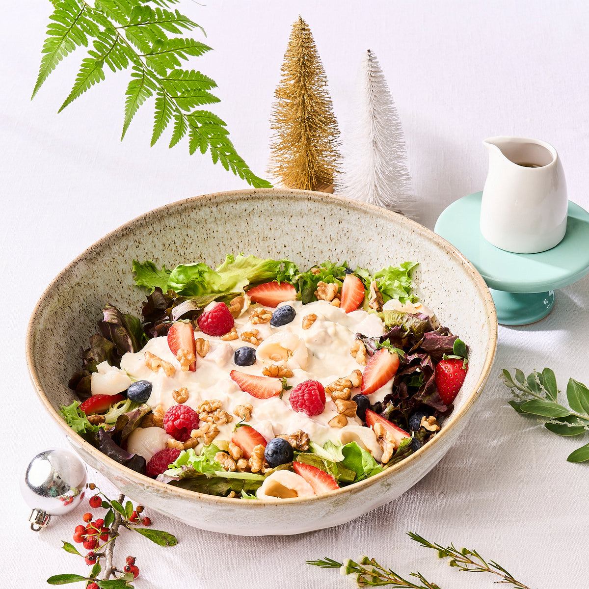 Christmas salad bowl with greens, berries, walnuts and creamy lychee turkey topping