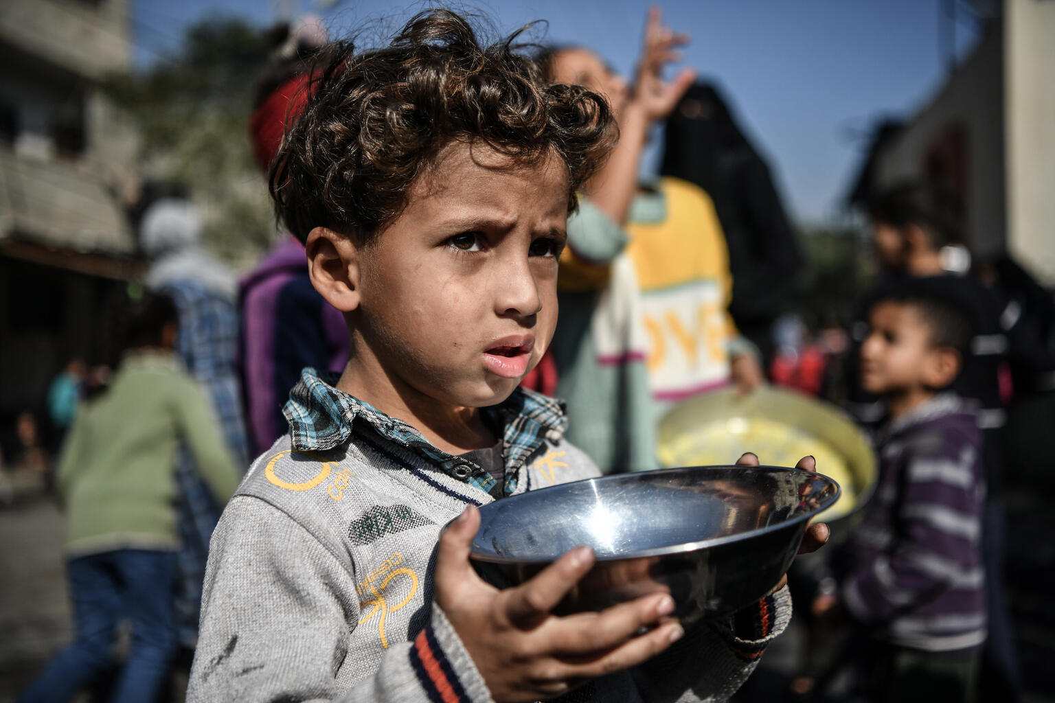 Ahmad, 5-years-old, waits his turn in the crowd to get a meal from a charitable hospice that distributes free food in the city of Rafah, southern the Gaza Strip. Source: Unicef - Abed Zagout